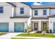 Exterior of townhome featuring a colorful garage door, a tidy walkway, and manicured lawn leading to the inviting front door at 781 Poppy Ln, Dundee, FL 33838