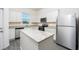 Modern kitchen with stainless steel appliances, white cabinets, a stylish island, and durable gray countertops at 781 Poppy Ln, Dundee, FL 33838