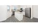 Bright kitchen features stainless steel appliances, white cabinets, and gray granite countertops with a functional island at 781 Poppy Ln, Dundee, FL 33838