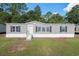 Charming single-story home featuring gray siding, black shutters, and a well-manicured lawn at 40144 Camphor Rd, Lady Lake, FL 32159