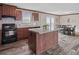 Stylish kitchen with granite countertops, an island with dark wood cabinets, and modern appliances at 40144 Camphor Rd, Lady Lake, FL 32159