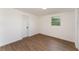 Bright bedroom featuring wood-look floors, a window, and a white door at 833 N Suwannee Ave, Lakeland, FL 33815