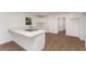 Bright kitchen with quartz countertop, white cabinets, stainless appliances and wood-look floors at 833 N Suwannee Ave, Lakeland, FL 33815