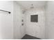 Shower featuring white marble-look tiles, a black shower floor, and a rainfall shower head at 833 N Suwannee Ave, Lakeland, FL 33815