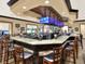 Upscale bar features a granite countertop, dark wood trim, seating, and multiple televisions at 1074 Canary S Cir, Lakeland, FL 33809