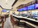 Upscale bar featuring granite countertop, dark wood trim, seating, and multiple TVs for entertainment at 1074 Canary S Cir, Lakeland, FL 33809
