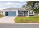 Charming single-story home featuring a blue garage door and front door, nicely landscaped front yard, and stone accents at 1074 Canary S Cir, Lakeland, FL 33809