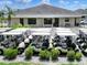 Exterior view of the clubhouse with many golf carts parked in the lot and trimmed bushes out front at 1074 Canary S Cir, Lakeland, FL 33809