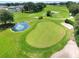 A bird's eye view of a well-kept green, with a pond, sand traps and a scenic stream at 1074 Canary S Cir, Lakeland, FL 33809
