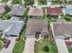 Birds-eye view of a residential home and neighborhood with manicured lawns and mature landscaping at 879 Astor Way, The Villages, FL 32162