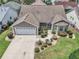 Aerial view of a well-maintained home showcasing its roof, landscaping, and a spacious driveway at 879 Astor Way, The Villages, FL 32162