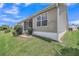 Exterior view of a home's backyard, featuring a screened-in patio and well-maintained lawn at 879 Astor Way, The Villages, FL 32162