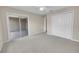 Bedroom showcasing neutral walls, plush carpet, ceiling fan, sliding doors, and a large closet at 879 Astor Way, The Villages, FL 32162