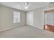 Bright bedroom with plush carpet, ceiling fan, and window providing ample natural light at 879 Astor Way, The Villages, FL 32162