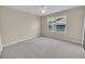 Bright bedroom with neutral walls, plush carpet, ceiling fan, and a large window offering natural light at 879 Astor Way, The Villages, FL 32162