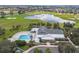 Aerial view of a community center, pool, and manicured grounds near a scenic golf course at 879 Astor Way, The Villages, FL 32162