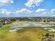 Scenic aerial view of a beautiful golf course with a serene lake and well-manicured greens at 879 Astor Way, The Villages, FL 32162