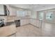 Bright kitchen features white cabinetry, neutral countertops, and stainless steel appliances at 879 Astor Way, The Villages, FL 32162