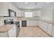 Bright kitchen featuring white cabinets, black appliances, and neutral countertops at 879 Astor Way, The Villages, FL 32162