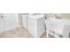 Functional laundry room with modern washer, dryer, and utility sink on ceramic tile flooring at 879 Astor Way, The Villages, FL 32162