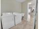Efficient laundry area featuring a washer, dryer, and utility sink with tile flooring at 879 Astor Way, The Villages, FL 32162