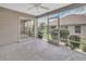 Relaxing screened-in patio with concrete flooring offering a view of the well-maintained yard at 879 Astor Way, The Villages, FL 32162