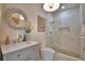 Well-lit bathroom featuring a glass shower, decorative mirror, and modern vanity with gold hardware at 359 Terminal Ave, Polk City, FL 33868