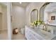 Bright bathroom featuring double sinks, gold hardware, and elegant mirrors above a white vanity at 359 Terminal Ave, Polk City, FL 33868