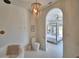 Elegant bathroom featuring a freestanding tub, toilet, chandelier, and view into the main bedroom at 359 Terminal Ave, Polk City, FL 33868