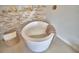 Modern freestanding bathtub with stone accent wall and built-in shelving for toiletries at 359 Terminal Ave, Polk City, FL 33868