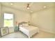 Simple bedroom featuring a window with a view, ceiling fan, neutral walls, and a patterned bedspread at 359 Terminal Ave, Polk City, FL 33868