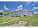 Spacious home exterior with a covered carport, a white patio and green grass and blue sky at 359 Terminal Ave, Polk City, FL 33868
