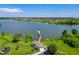 View the scenic lake with a fishing pier, playground, and gazebo offering serene outdoor enjoyment at 5660 Elsinore Way, Lakeland, FL 33805