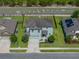 Aerial view of a charming home boasting a well-manicured lawn, fenced yard, and attached two car garage at 5660 Elsinore Way, Lakeland, FL 33805