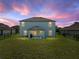 Spacious backyard with green lawn, a covered patio, and black fence, perfect for outdoor activities at 5660 Elsinore Way, Lakeland, FL 33805