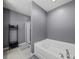 Primary bathroom featuring a stand up shower and separate tub, with gray walls and tile floors at 5660 Elsinore Way, Lakeland, FL 33805