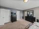 Carpeted primary bedroom featuring two black dressers and adjacent bathroom and closet doors at 5660 Elsinore Way, Lakeland, FL 33805