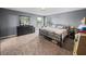 Bedroom featuring a large bed, soft carpet, and a dresser with mirror across two windows at 5660 Elsinore Way, Lakeland, FL 33805
