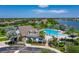 Community pool area with ample seating, lush landscaping, and a serene lake backdrop in an aerial view at 5660 Elsinore Way, Lakeland, FL 33805