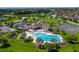 Aerial shot of a community pool with palm trees, tennis courts, and a clubhouse for residents to enjoy at 5660 Elsinore Way, Lakeland, FL 33805