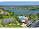 Aerial view showcases a community pool, tennis courts, lake, and well-maintained landscaping at 5660 Elsinore Way, Lakeland, FL 33805