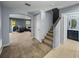 Inviting entryway showcasing carpeted stairs, ceramic tile, and entrances to the bathroom and living room at 5660 Elsinore Way, Lakeland, FL 33805
