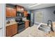 Functional kitchen boasts granite countertops, stainless steel appliances, and neutral tile flooring at 5660 Elsinore Way, Lakeland, FL 33805