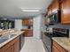Well-lit kitchen features granite countertops, stainless steel appliances, and ample cabinet space at 5660 Elsinore Way, Lakeland, FL 33805
