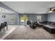 Spacious living room featuring large windows, plush carpeting, and sliding glass doors to a backyard view at 5660 Elsinore Way, Lakeland, FL 33805