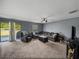 Spacious living room with sliding glass doors to the backyard, plush seating, and neutral gray walls at 5660 Elsinore Way, Lakeland, FL 33805