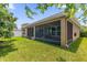 Exterior view of a home with a screened patio and a well-maintained lawn at 1111 Bassano Way, Orlando, FL 32828