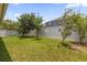 Backyard featuring a well-manicured lawn, privacy fence, and young trees, creating a serene outdoor space at 1111 Bassano Way, Orlando, FL 32828