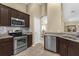 Modern kitchen features stainless steel appliances, granite countertops, and dark wood cabinetry at 1111 Bassano Way, Orlando, FL 32828