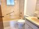 Clean bathroom featuring a shower/tub combination, grab bars, and neutral tile at 8386 Sw 105Th Pl, Ocala, FL 34481